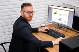 Service business owner sitting at a desk searching their own business name on a laptop, viewing Google search results showing their star rating, reviews, and knowledge panel